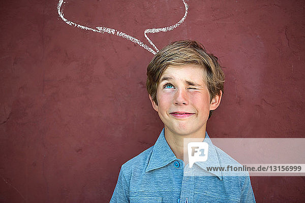 Boy looking up at speech bubble on red wall