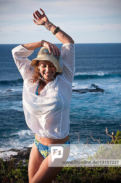 Woman stretching on coastal cliffs