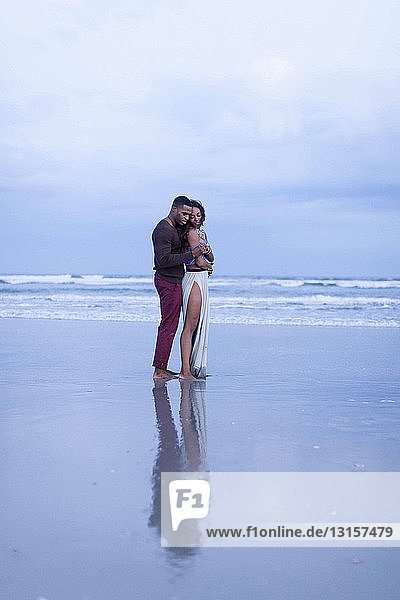 Couple standing on beach  hugging