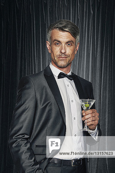 Portrait of man in tuxedo with cocktail