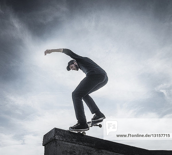 Junger Mann fährt Skateboard auf dem Dach