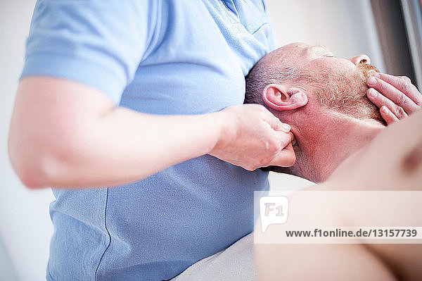 Mann auf dem Rücken liegend  Kopfmassage