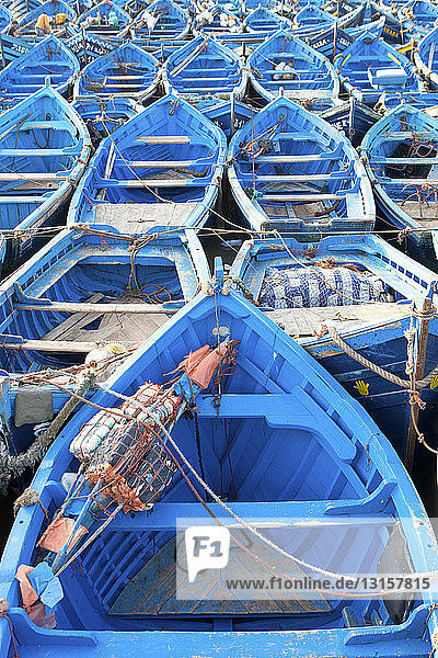 Rows of blue fishing boats anchored on waterfront  Essaouira  Morocco