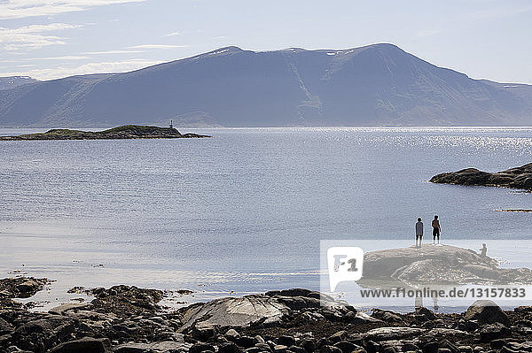 Three people standing on Fjord rocks  Alesund  Norway