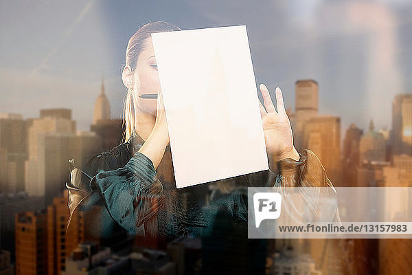 Frau am Fenster mit Spiegelung der Stadt