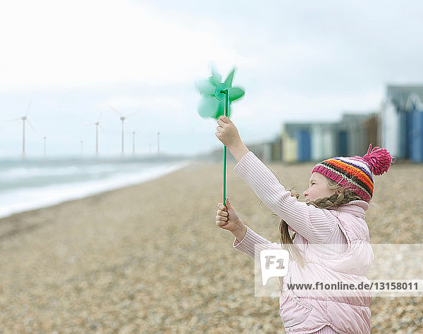 junges Mädchen mit Windmühle am Strand