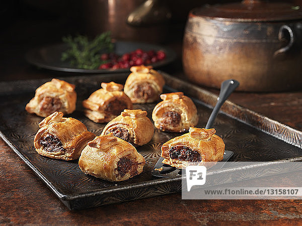 Baking tray of sausage rolls with cranberries