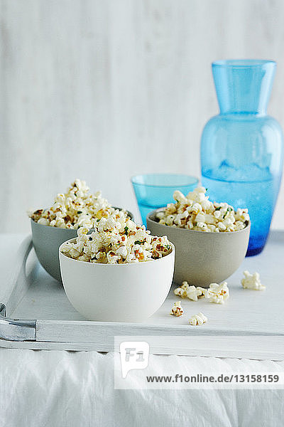 Schalen mit aromatisiertem Popcorn auf dem Tisch