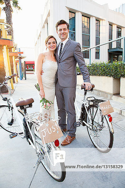 Porträt eines jungen  frisch verheirateten Paares mit Fahrrädern