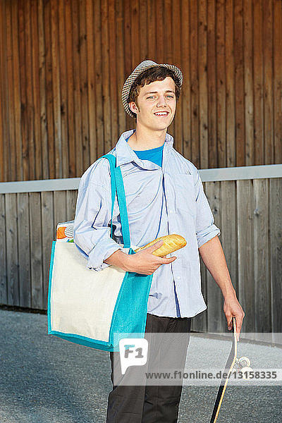 Young man with skateboard and shopping