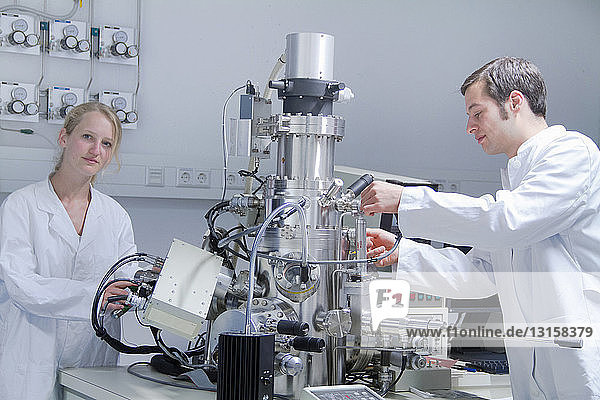 Zwei Wissenschaftler in Laborkitteln mit wissenschaftlicher Ausrüstung