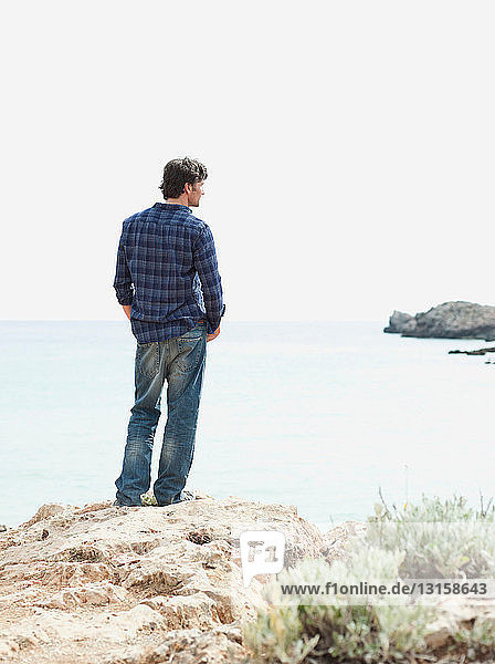 man looking at coastline