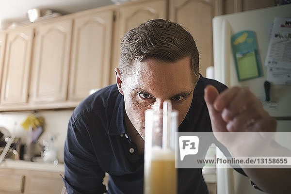 Mid adult man checking hydrometer for home brew beer