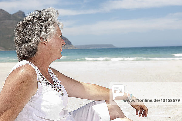 Ältere Frau entspannt am Strand