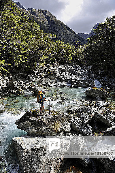 Frau steht auf Felsen im Fluss  Neuseeland