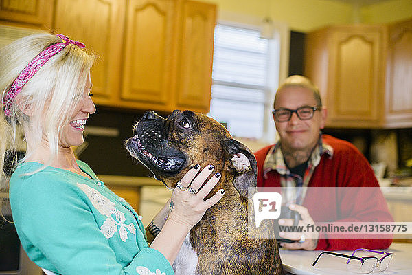 Junge Frau lächelt Boxerhund an  von Angesicht zu Angesicht
