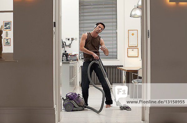 man vacuuming and listening to music