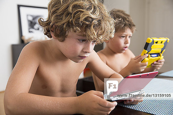 Jungen spielen mit tragbarer Spielkonsole