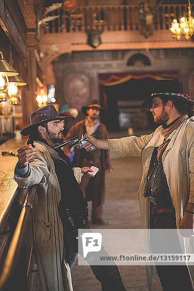 Cowboy zielt mit einer Handfeuerwaffe in einem Saloon am Set eines Wildwestfilms  Fort Bravo  Tabernas  Almeria  Spanien