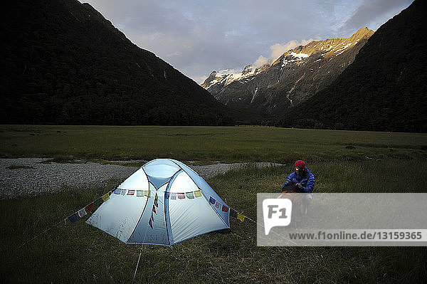 Frau beim Zelten in der Abenddämmerung  Neuseeland
