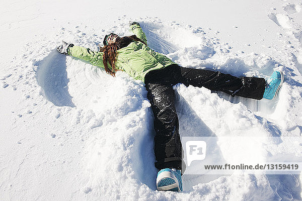 Young woman making snow angel  Kuhtai  Austria