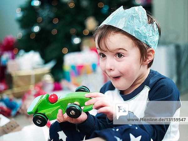 Junge öffnet Weihnachtsgeschenke