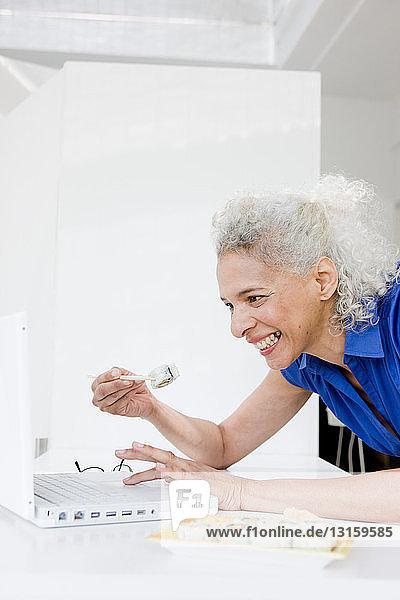 Businesswoman lunching at laptop