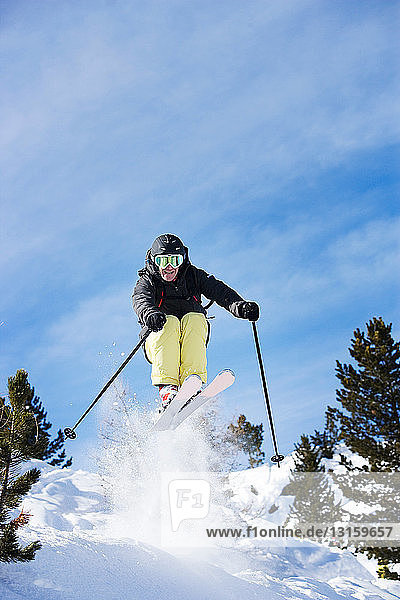 Männlicher Skifahrer in der Luft am Berghang