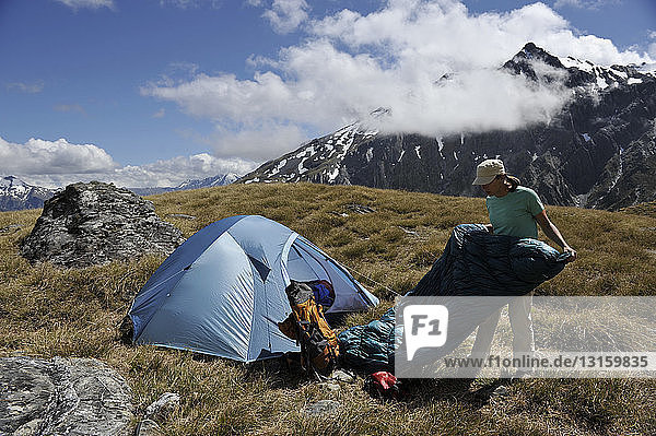 Mid adult woman camping in mountains  New Zealand