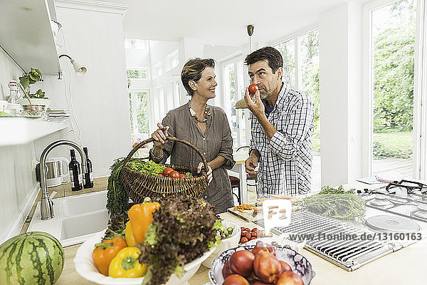 Ehepaar in der Küche bei der Zubereitung von frischem Gemüse