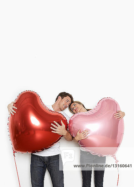 Ehepaar hält Herzballons