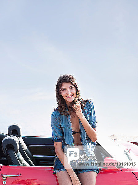 woman leaning at car smiling