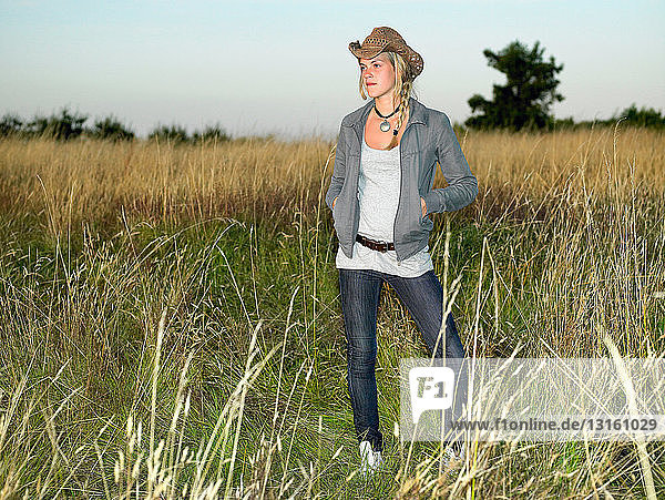 Girl with hat  standing in a field