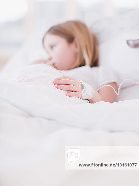 girl in bed with needle fixed to hand