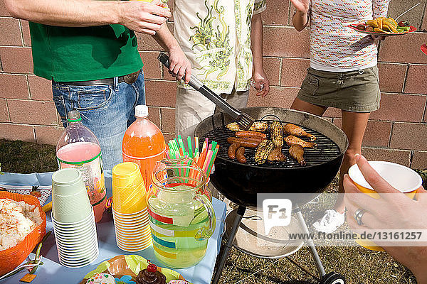 Man cooking with friends at barbecue