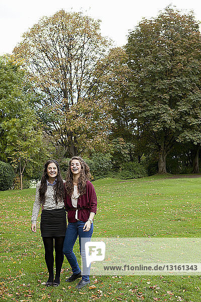Lächelnde Mädchen stehen im Park