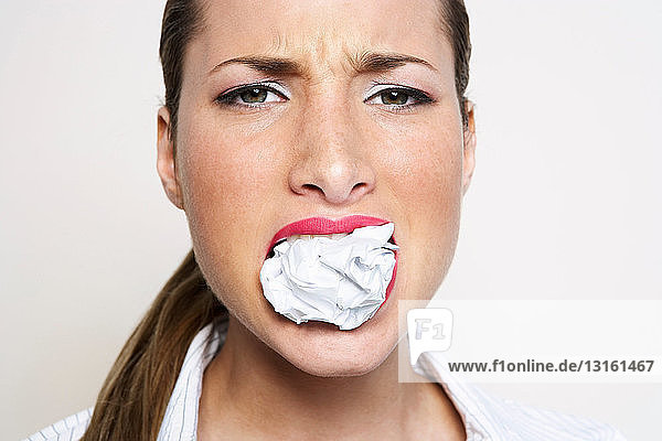 Frau mit Papierkugel im Mund