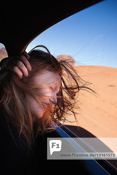 Woman with windswept hair at car window  Monument Valley  Utah  USA
