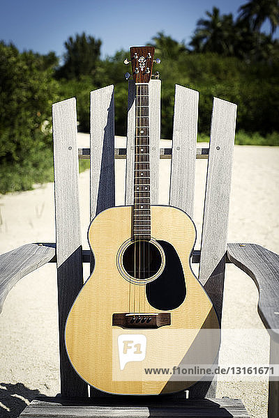 Akustische Gitarre auf hölzernem Strandkorb
