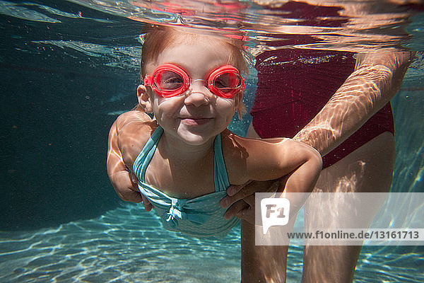 Unterwasserporträt eines Mädchens  das schwimmen lernt