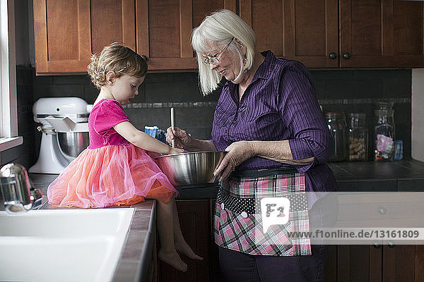 Großmutter und Enkelin backen Kekse