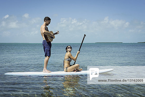 Junges Paar paddelnd und Gitarre spielend  Islamorada  Florida  USA