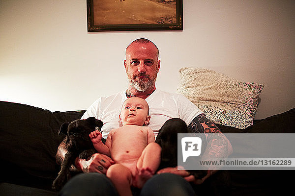 Vater mit kleinem Sohn auf dem Schoß auf dem Sofa
