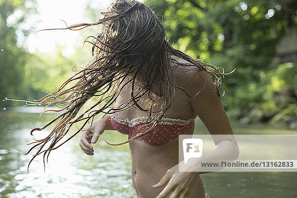 Teenager-Mädchen wäscht Haare im Fluss