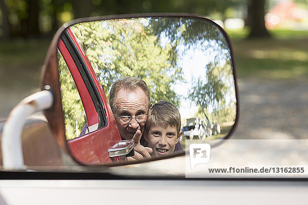 Älterer Mann und Enkel im Außenspiegel des Lastwagens reflektiert