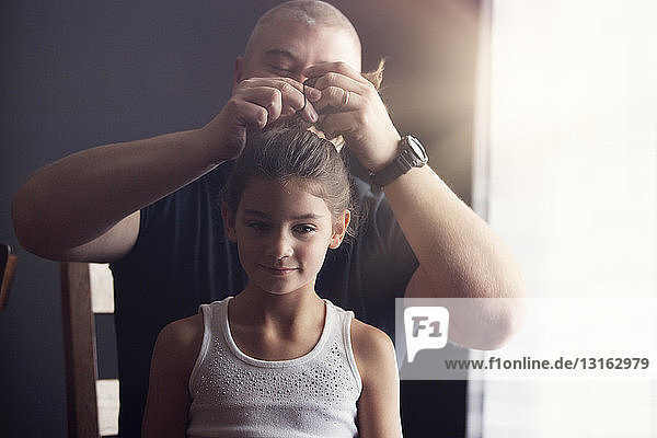 Vater macht seiner Tochter die Haare