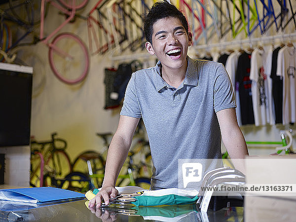 Porträt eines jungen Mannes  der im Fahrradladen lacht