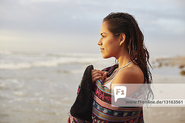 Porträt einer in ein Handtuch gewickelten jungen Frau am Strand  San Diego  Kalifornien  USA