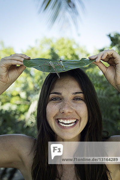 Portrait of young woman with leaf and insect on top of head  Islamorada  Florida  USA