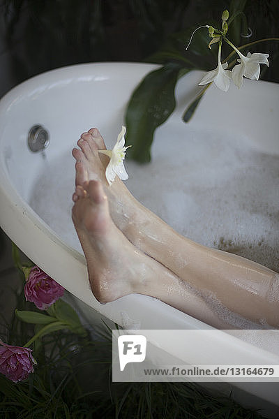 Junge Frau entspannt sich in der Badewanne  Füße auf dem Badewannenrand  Fokus auf die Füße